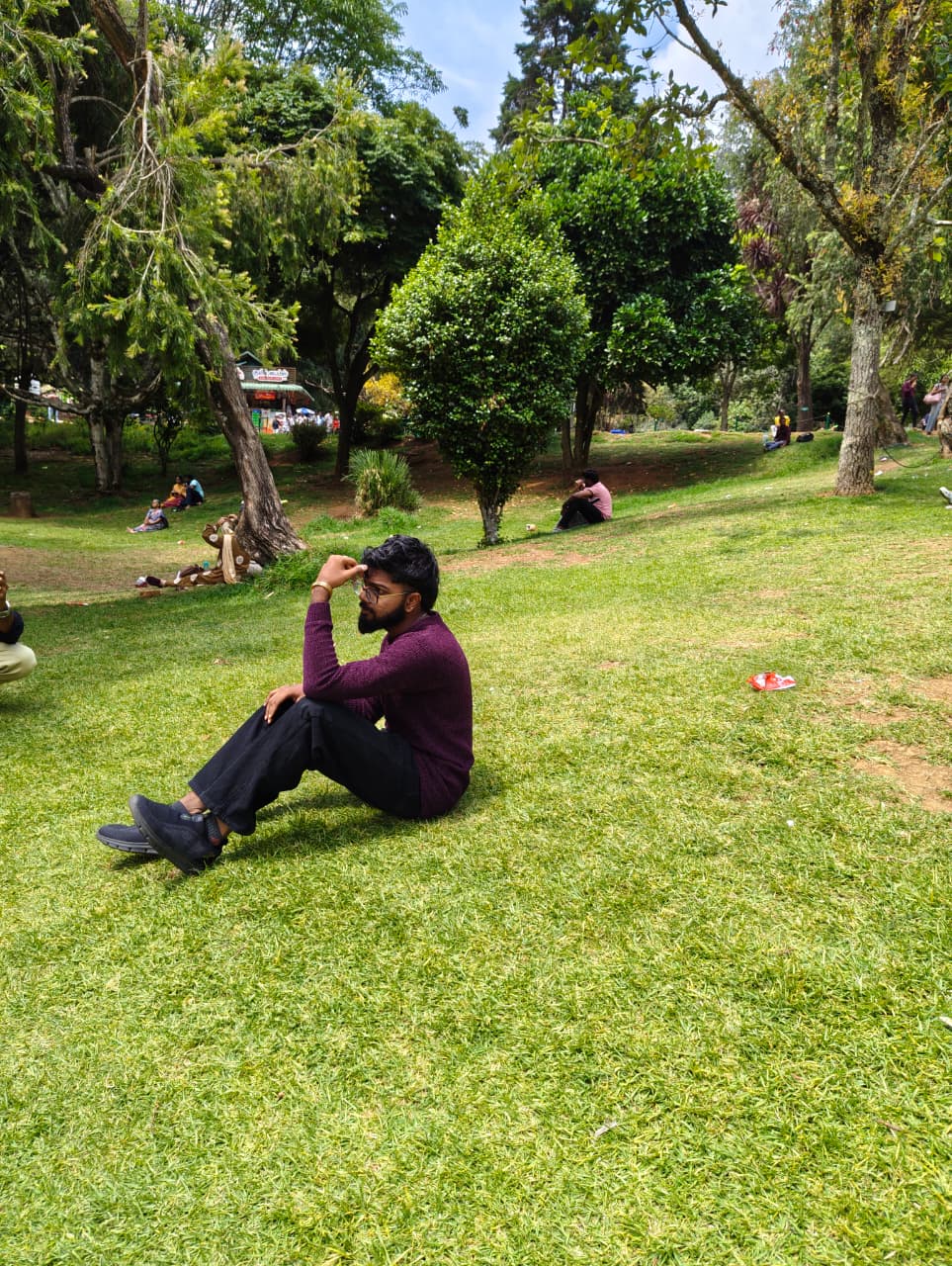 Aswath AS, sitting on grass in a park